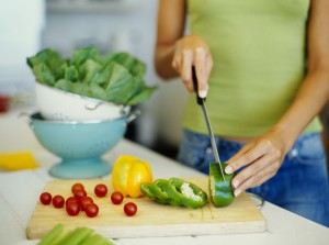 mid section view of a woman cutting vegetables